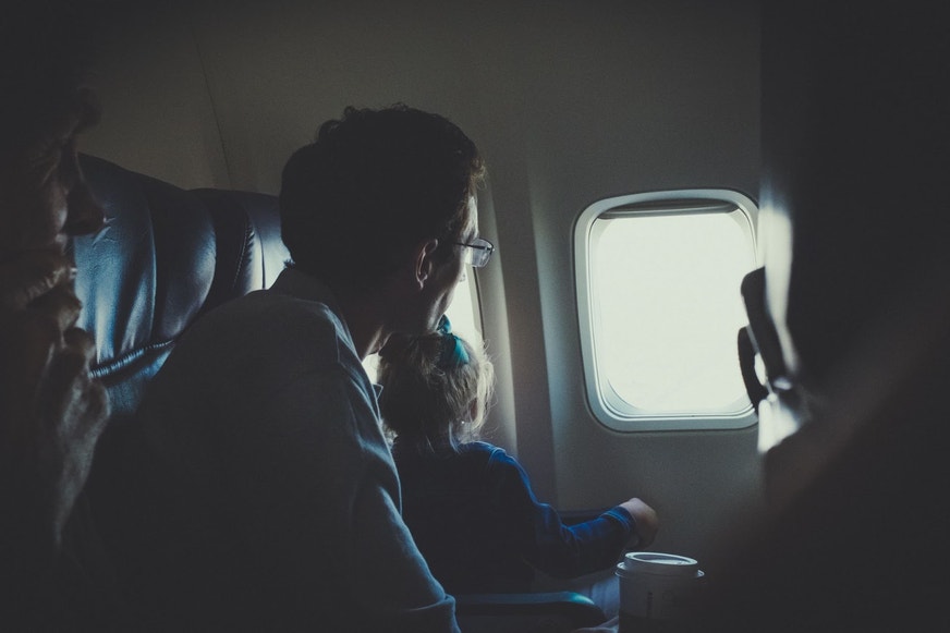 Father and daughter traveling on plane