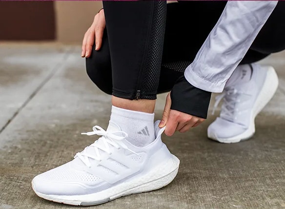 A person trying on Adidas sneakers.