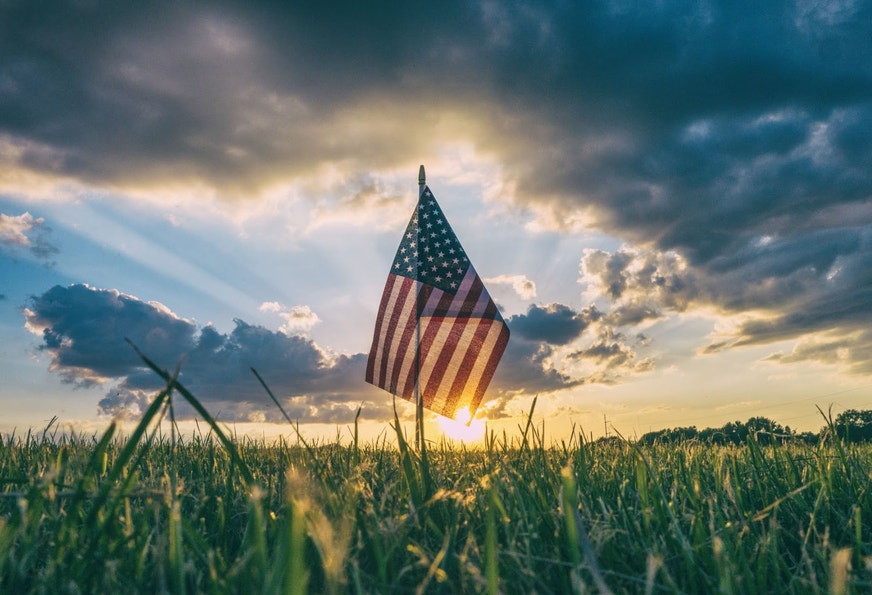 American flag in front of sunset